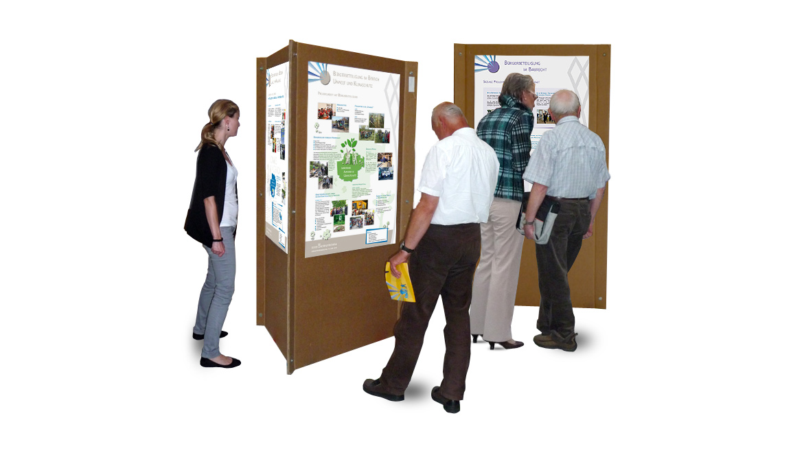 Menschen betrachten die Plakate auf den dreieckigen Ausstellungswänden bei der Bürgerversammlung der Stadt Kornwestheim.